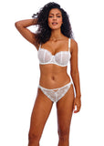 Woman wearing a white lace bra and panties set on a white background