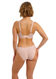 Woman wearing a beige lingerie set on a white background