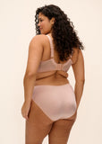 Woman wearing a beige bra and panties set on a beige background