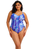 Woman wearing a blue and purple leaf-patterned swimsuit on a white background