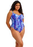 Woman wearing a blue and purple leaf-patterned swimsuit on a white background
