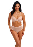 Woman wearing a beige bra and panties set on a white background