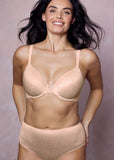 Woman wearing a pink bra and panties set against a plain background