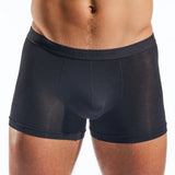 Black boxer briefs worn by a person on a white background