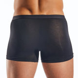 Black boxer briefs worn by a person on a white background