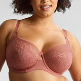 Woman wearing a pink bra against a gray background